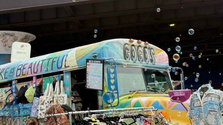 Soap bubbles float in front of a painted bus.